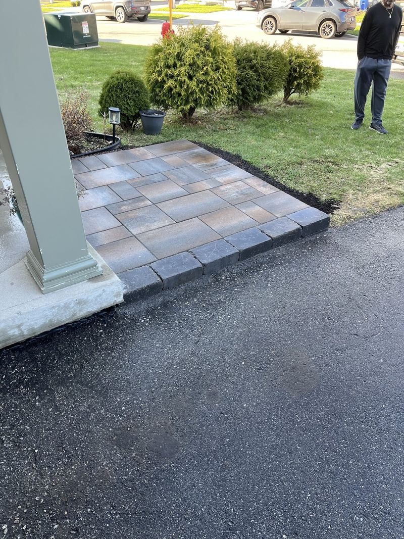 Interlock porch landing and walkway tying a covered front entry into the asphalt driveway